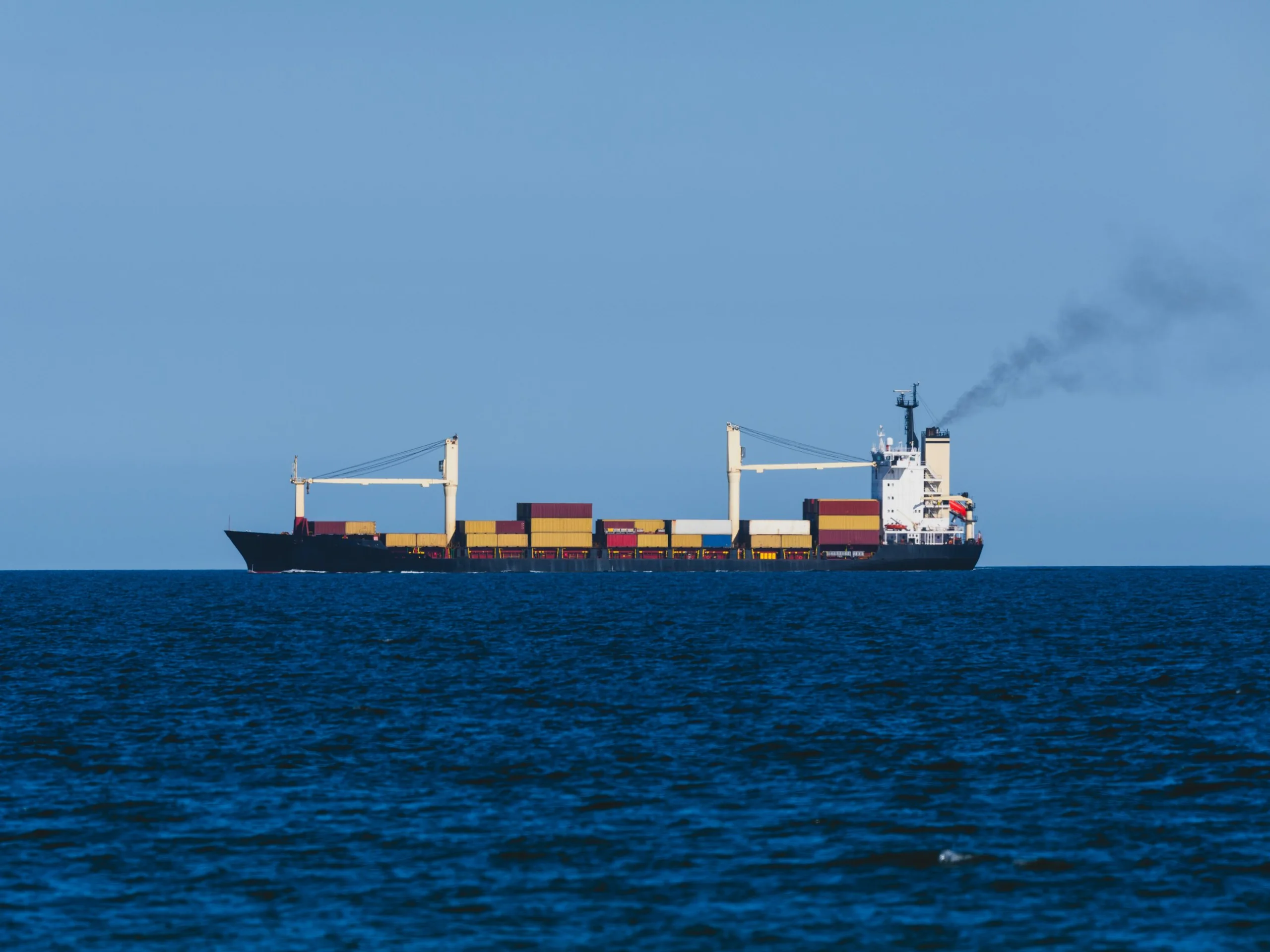 Container ship loaded with containers sailing on open sea